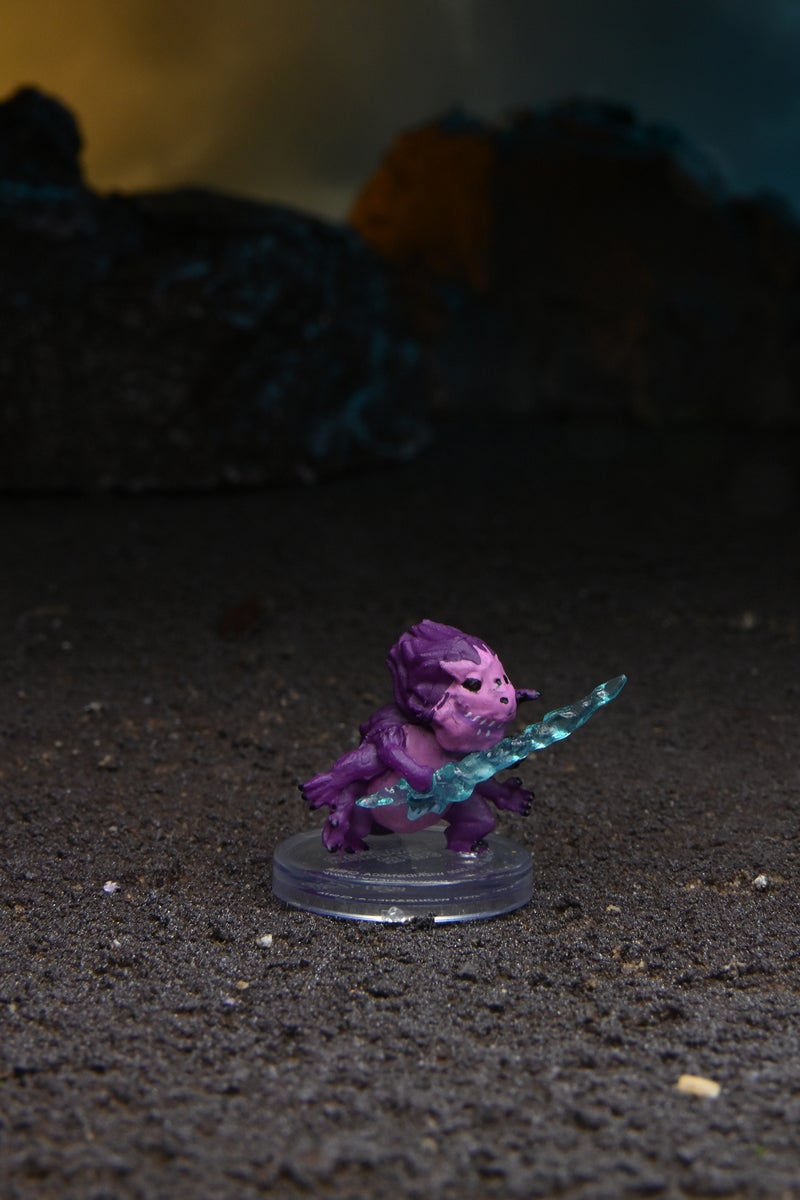 Mini figure of a small purple skittermander holding a blue translucent sword