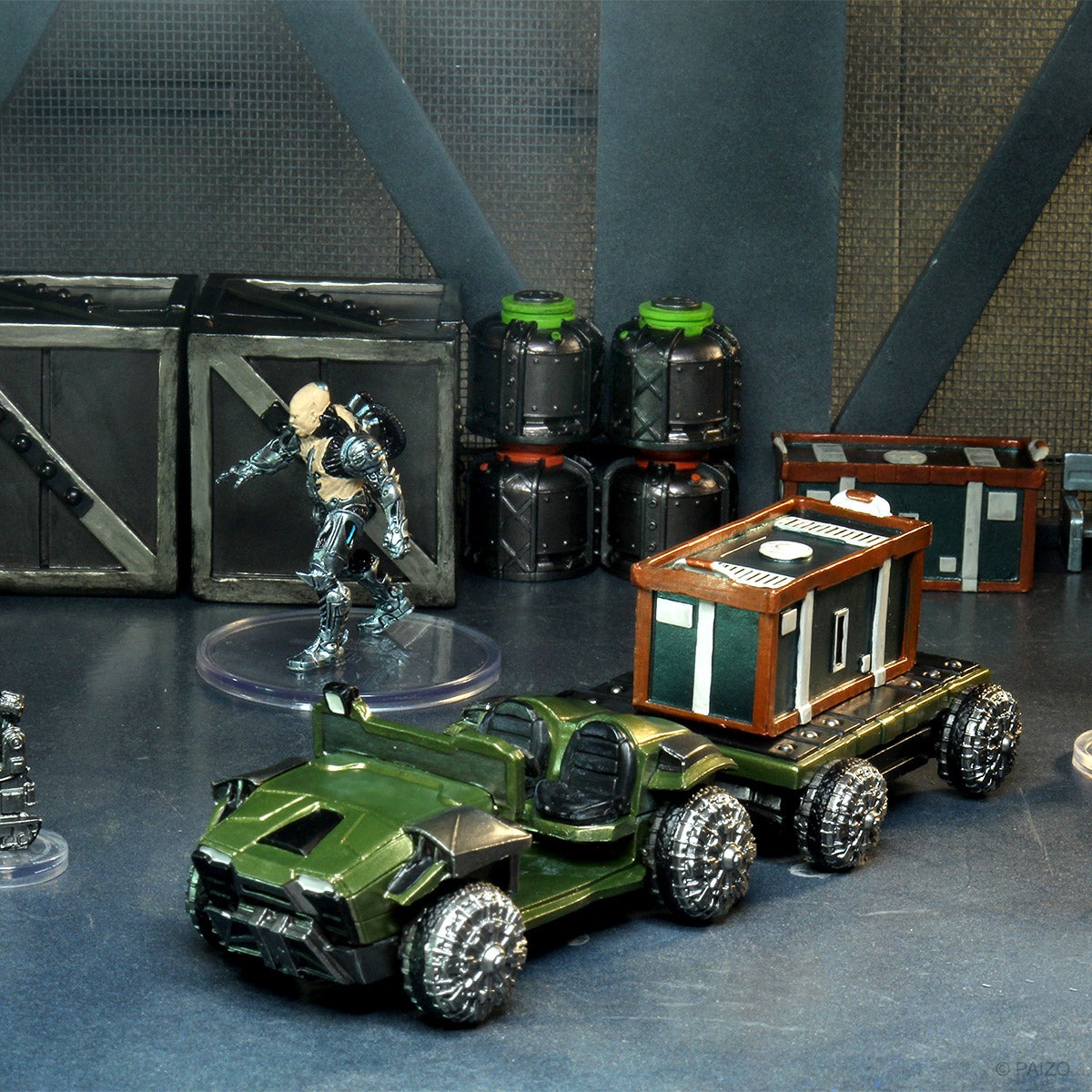 Mini figures set in a docking bay scene, featuring a transport vehicle towing a large box