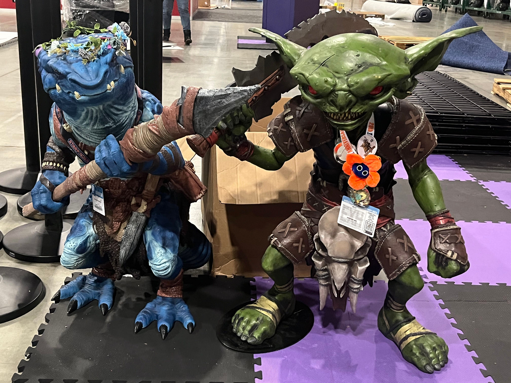 Life size foam figures of a blue Kobold holding a spear and a Goblin holding a large knife