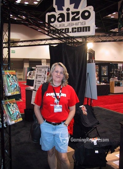 Lisa Stevens standing at the Paizo booth at a convention