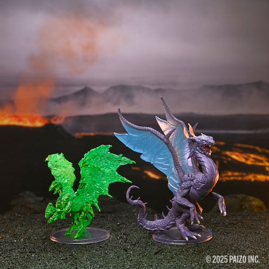 Two miniatures; a winged, green, skeletal horse; and a purple scaled dragon; sitting on textured ground with a lava field and active volcano in the background