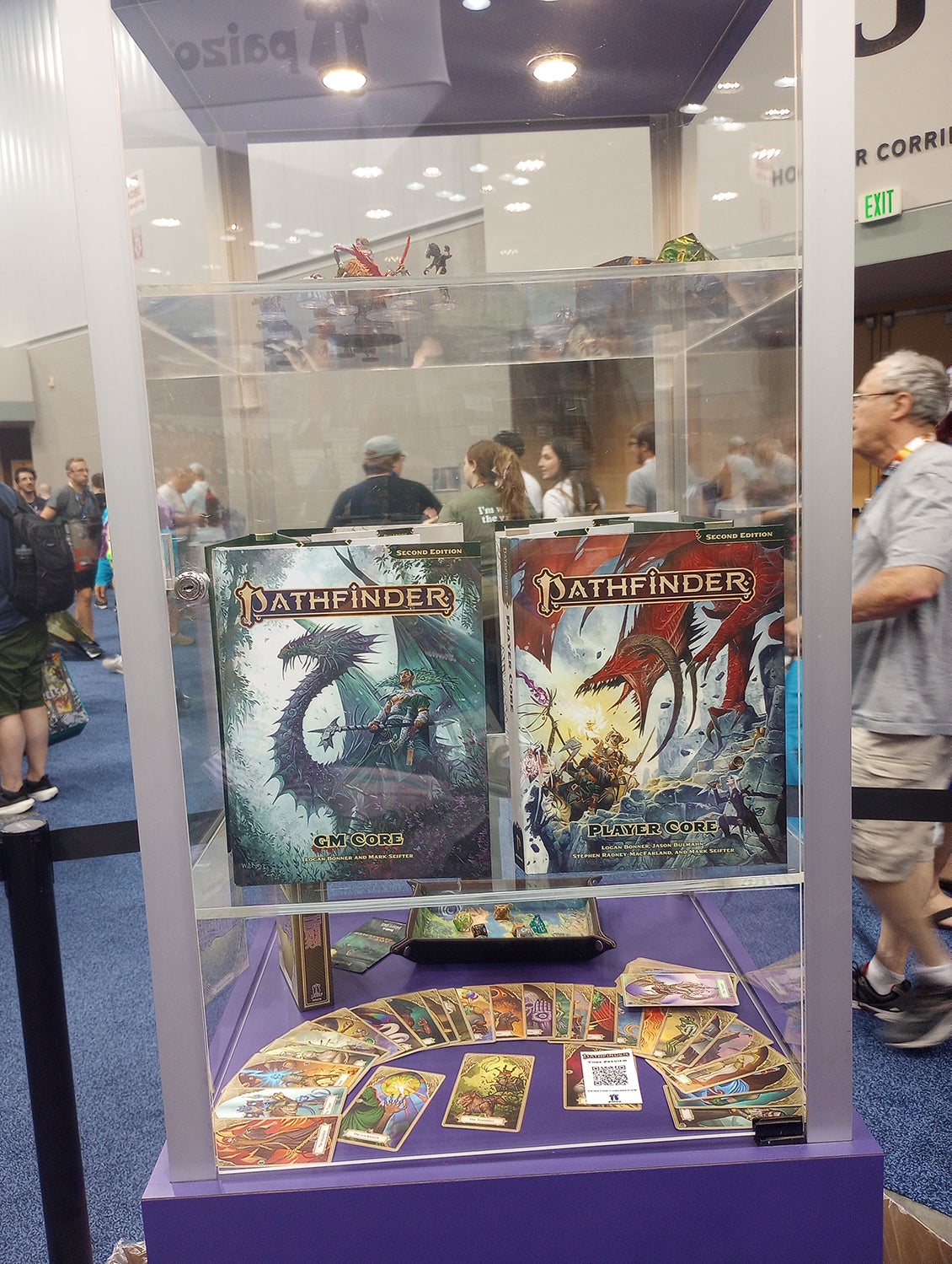 A show case at the Paizo Booth featuring the colored covers of the Pathfinder Second Edition Remaster GM Core and Player Core