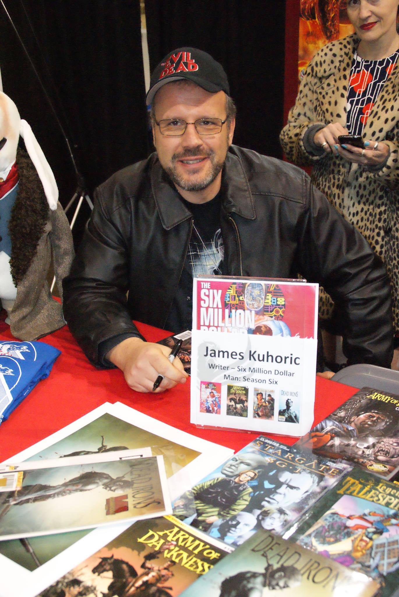 Dynamite comics' James Kuhoric sitting at an autograph booth
