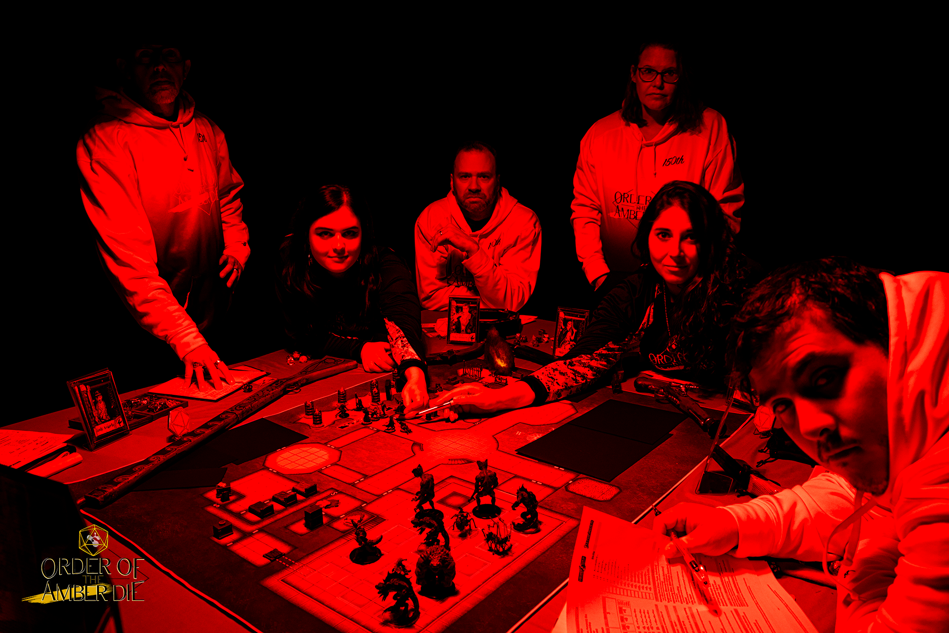 A group photo of the Order of the Amber Die play group under a dark red light