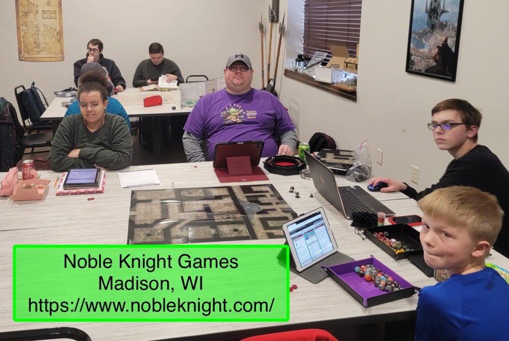 Photo by Patrick McElfresh - a group of society players sitting around a table with a flat map and miniatures in the center at Noble Knight Games in Madison Wisconsin