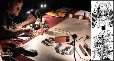 A man sitting at a gaming table drawing  on a notebook next to his character sheet. The gaming table is covered in a hand drawn map and miniatures.