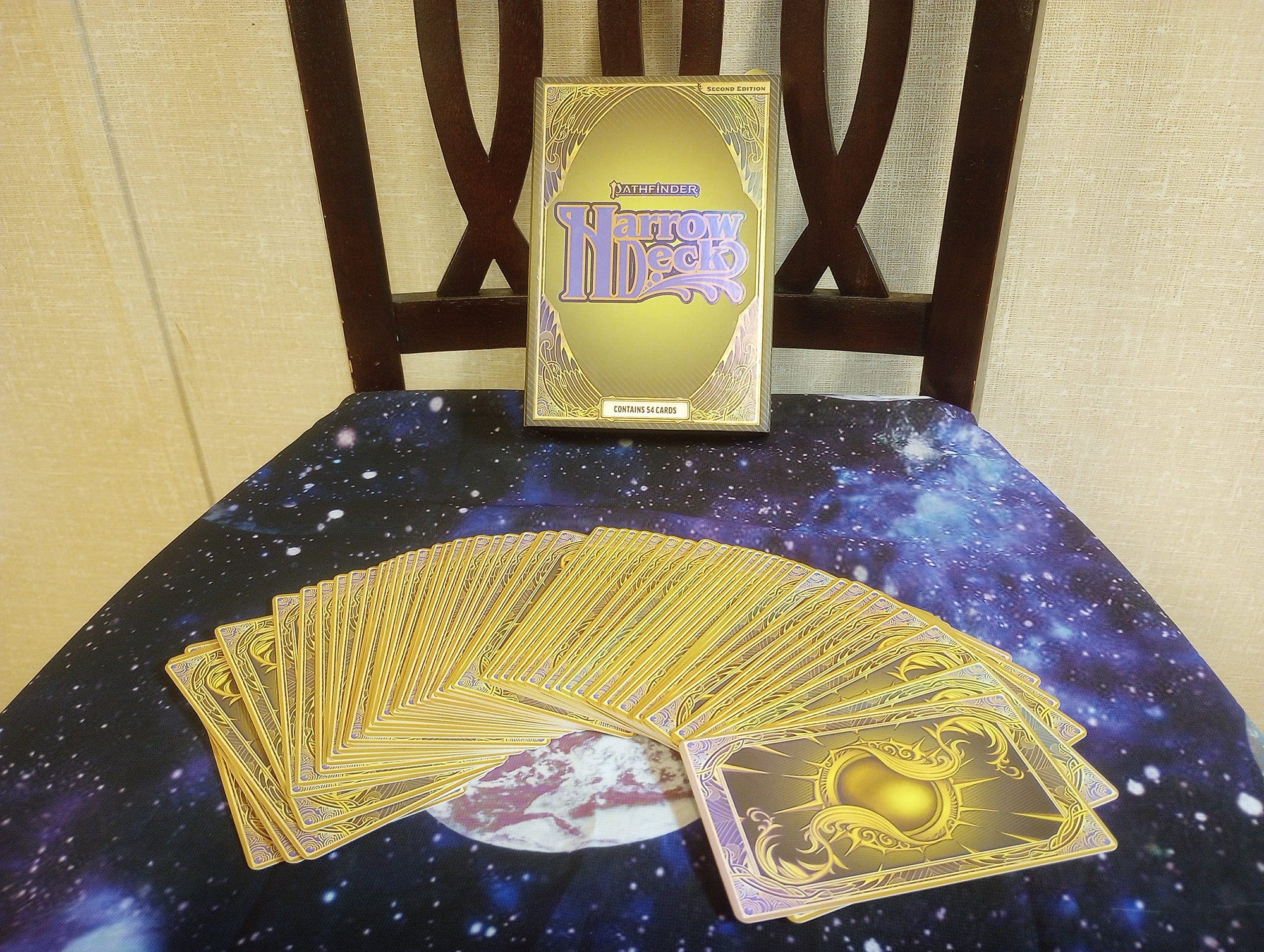 The Harrow Deck spread out across an alter cloth facedown, in front of the box.