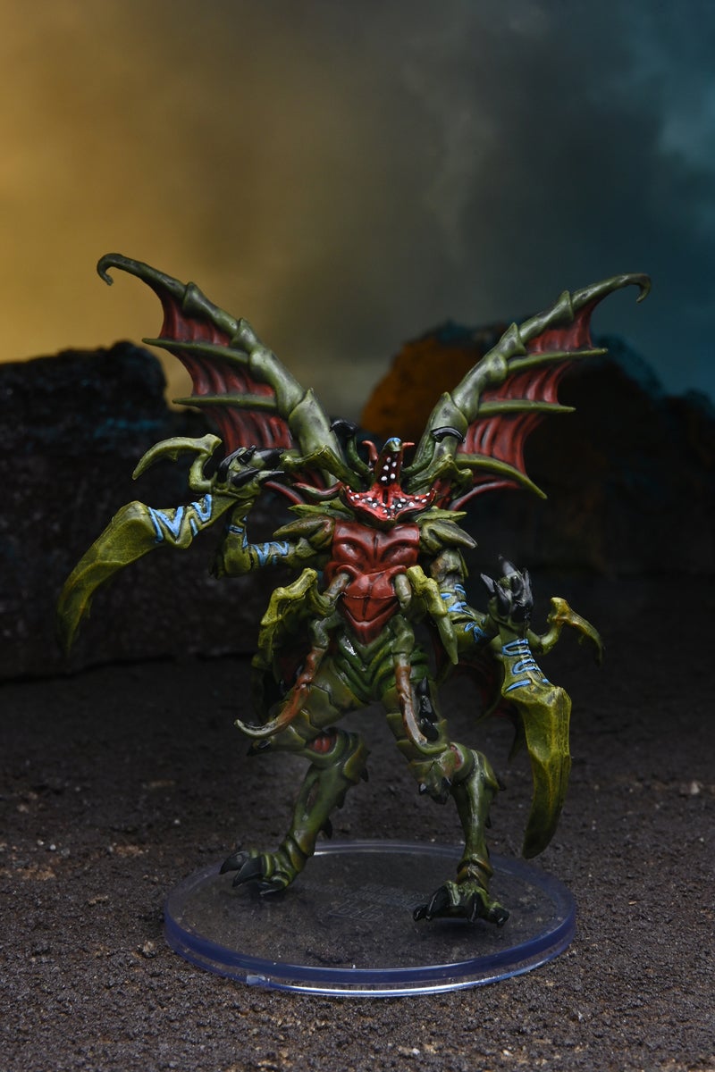 Mini figure of a thresher lord with large green and red wings, reaching out with large mandible-like claws