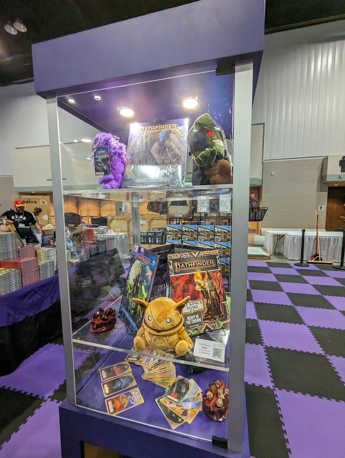 A show case at the Paizo Booth featuring a plush of iconic companion Whirp and the newest adventure paths