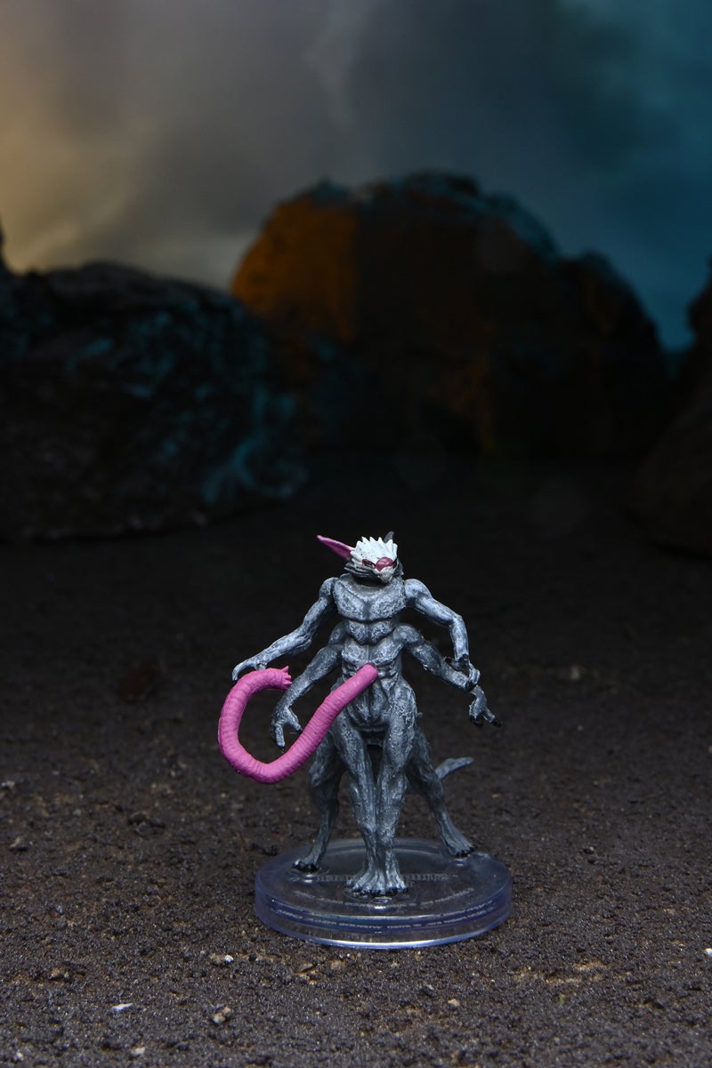 Mini figure of a stridermander, a four legged, four armed alien with a large tentacle-like limb protruding from its stomach