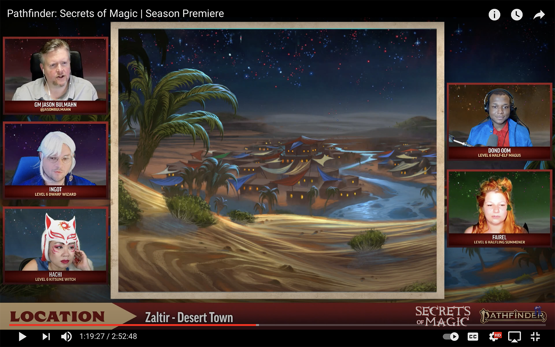 A screenshot of the Pathfinder Secrets of Magic liveplay on twitch. Jason, Xander, and Michelle are on the left side of the screen while London and Bonnie are on the right, with a large image of a desert town in the center