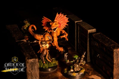 A mini figure large lizard-like creature stands over our players' figures, standing out ominously in the torchlight