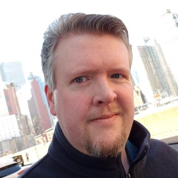 Headshot of Jason Bulmahn in front of a cityscape