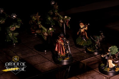 Player mini figures in the dark, surrounded by a hoard of boggard figures