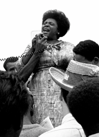 Fannie Lou Hamer at a protest, credit to William J. Smith. : A woman standing in a crowd with a microphone
