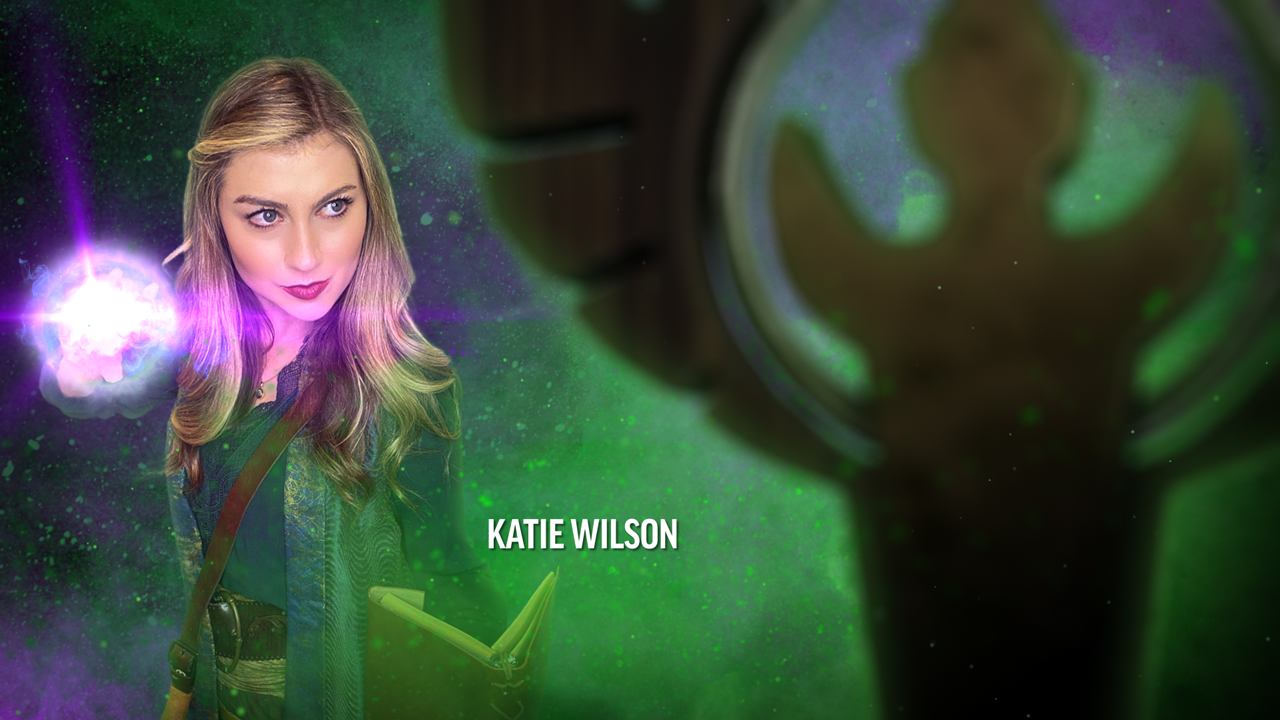 Katie Wilson, A blonde woman standing in a green and purple smokey background casting a bright spell from her fingers, as a statue to Serenrae sits in the foreground