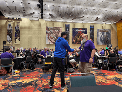 Organized Play Coordinator, Alex Speidel shaking hands with a volunteer