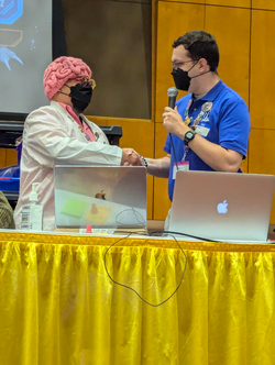 Organized Play Coordinator, Alex Speidel shaking hands with a volunteer