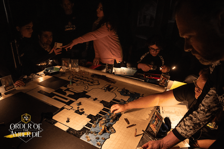 Areal view of a large flat dungeon map laid out on a table with players surrounding it