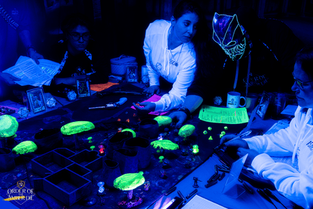 A group photo of the Order of the Amber Die play group under a black light