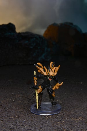 Mini figure of the Swarm Corrovox with brown armor growing from from its head, arms, and thighs 