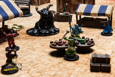 A model of a town marketplace, The players' figures suround and defend the market from a large Ooze