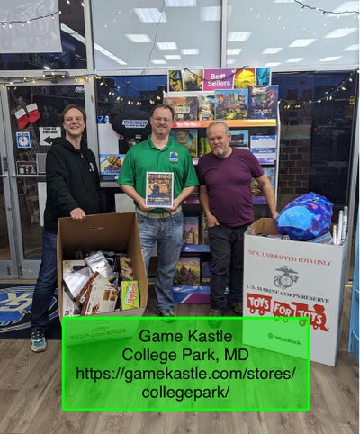 Photo Credit: Trevor Peryea -  three volunteers stand with two full toy bins for a holiday charity toy drive at Game Castle in College Park Maryland